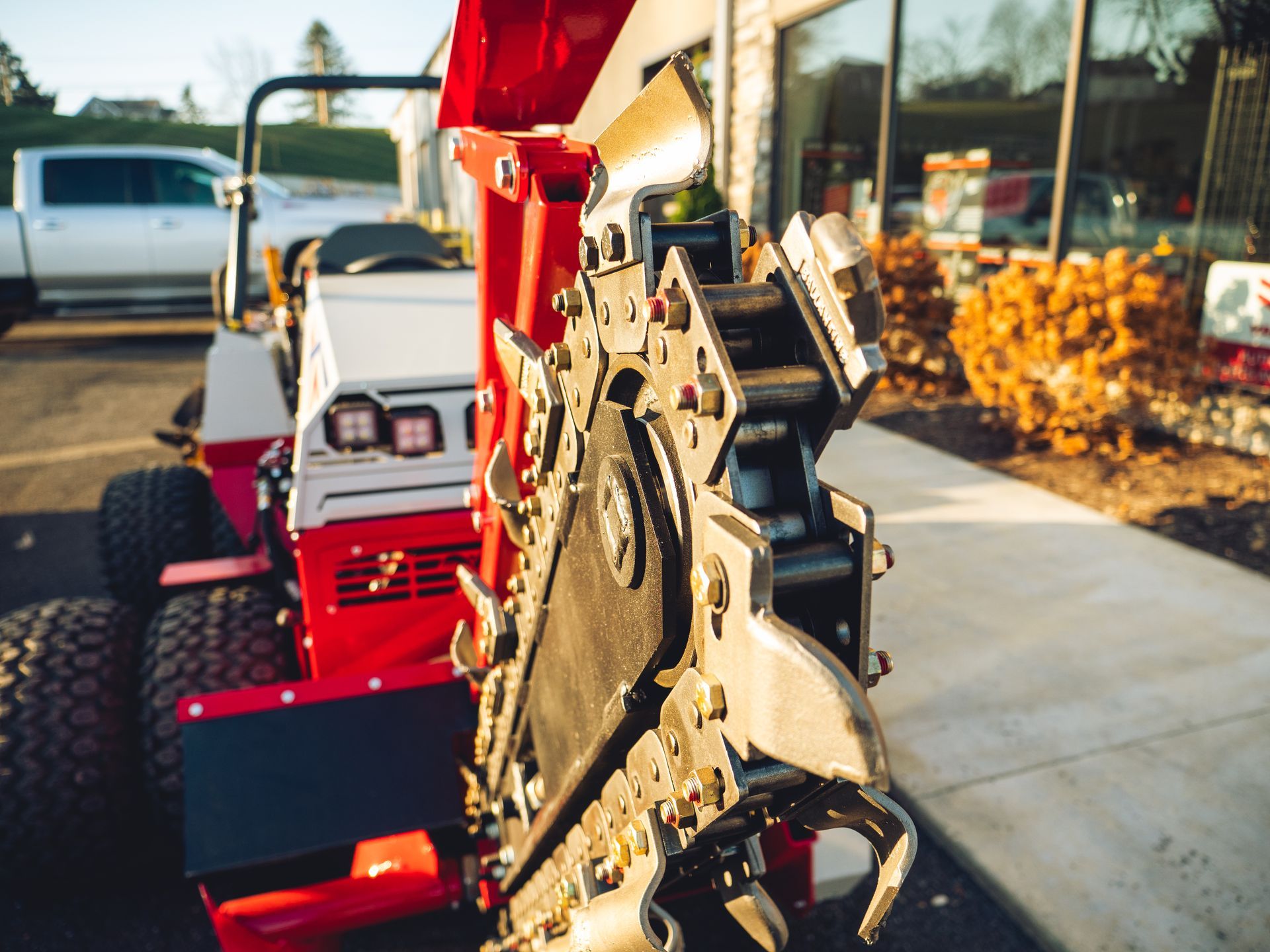 A red and white tractor is parked in a parking lot.