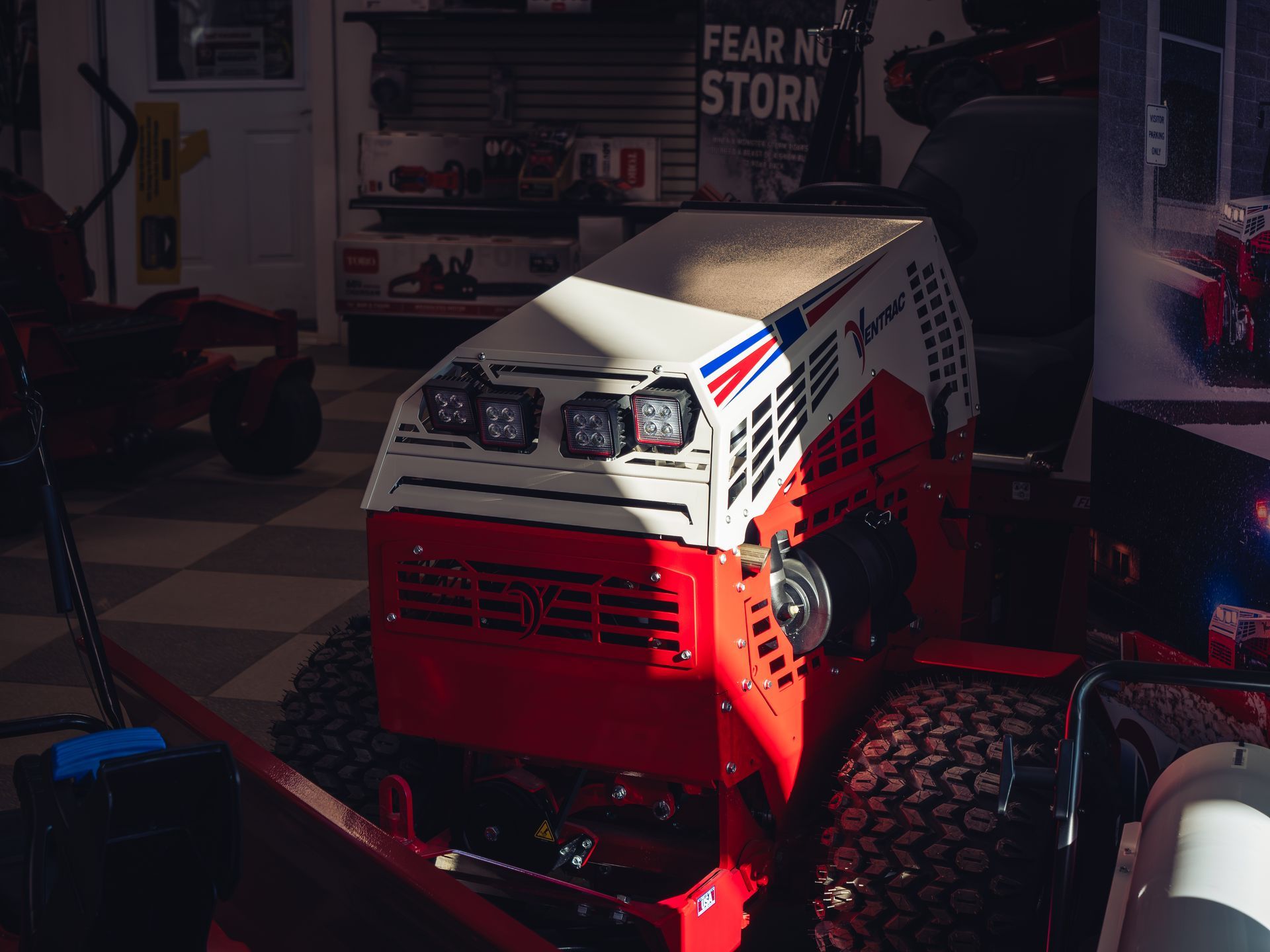 A red and white lawn mower is sitting in a garage.