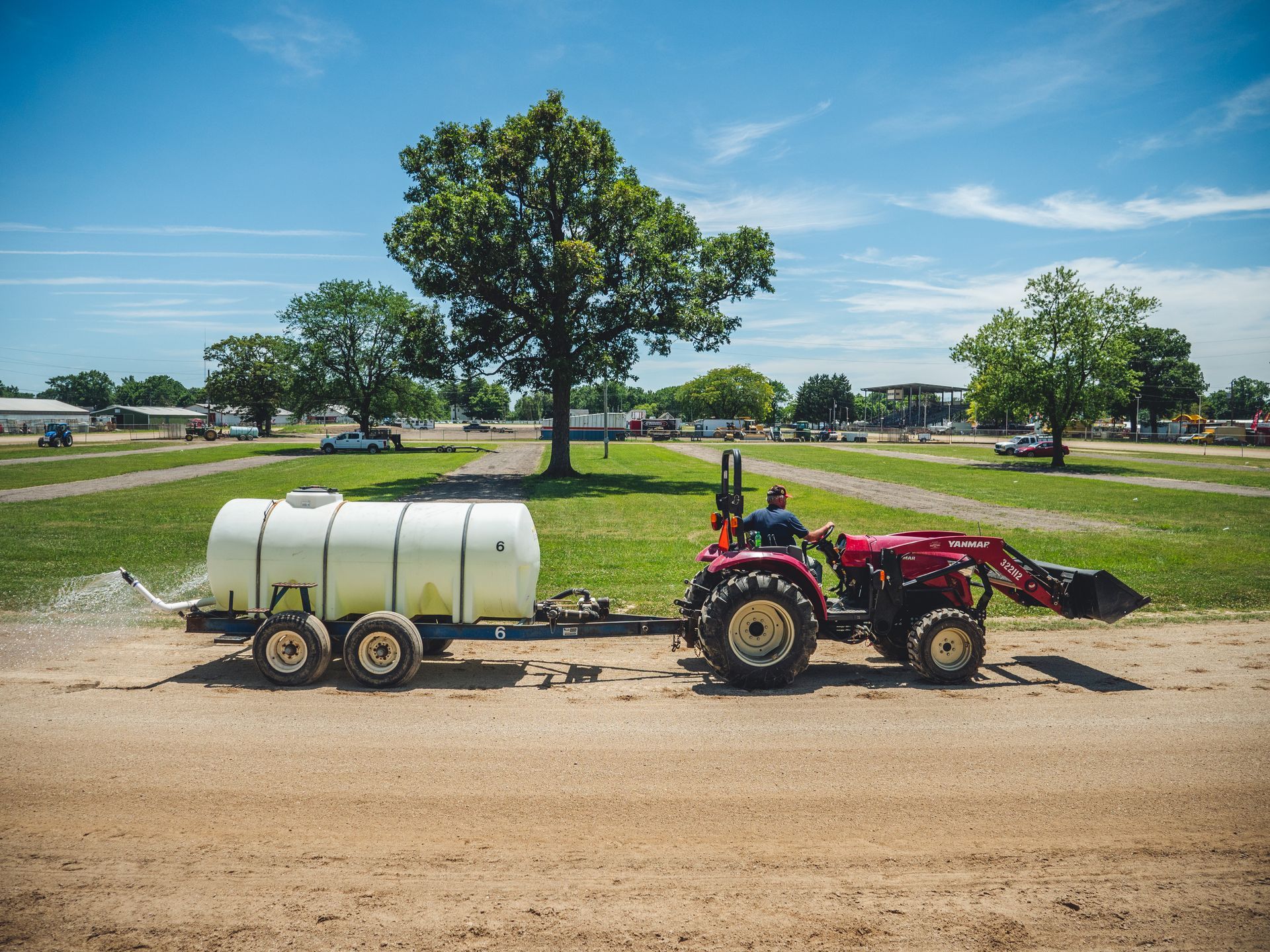 A tractor is pulling a trailer with a water tank attached to it.