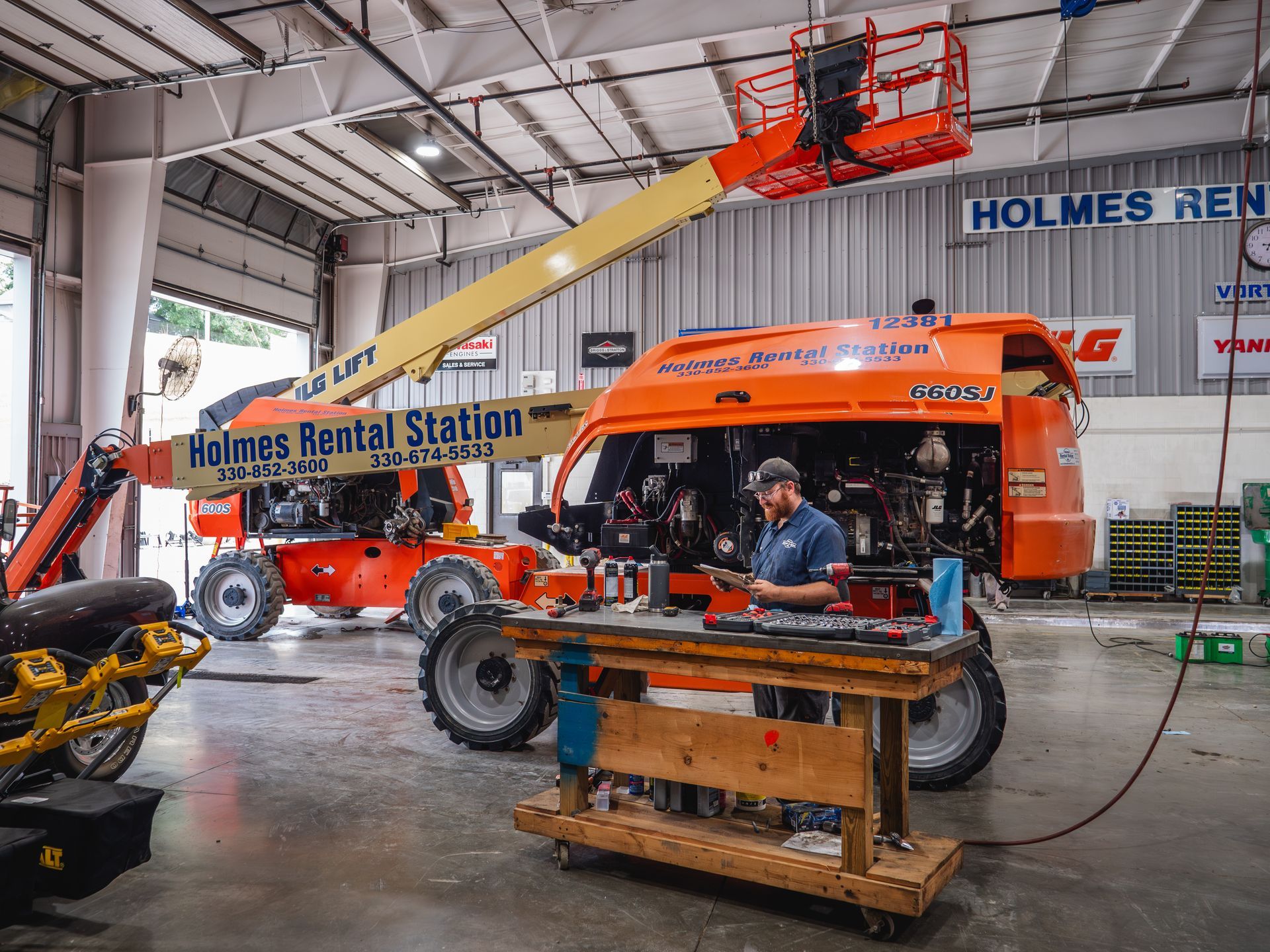 A man is working on a lift in a garage.