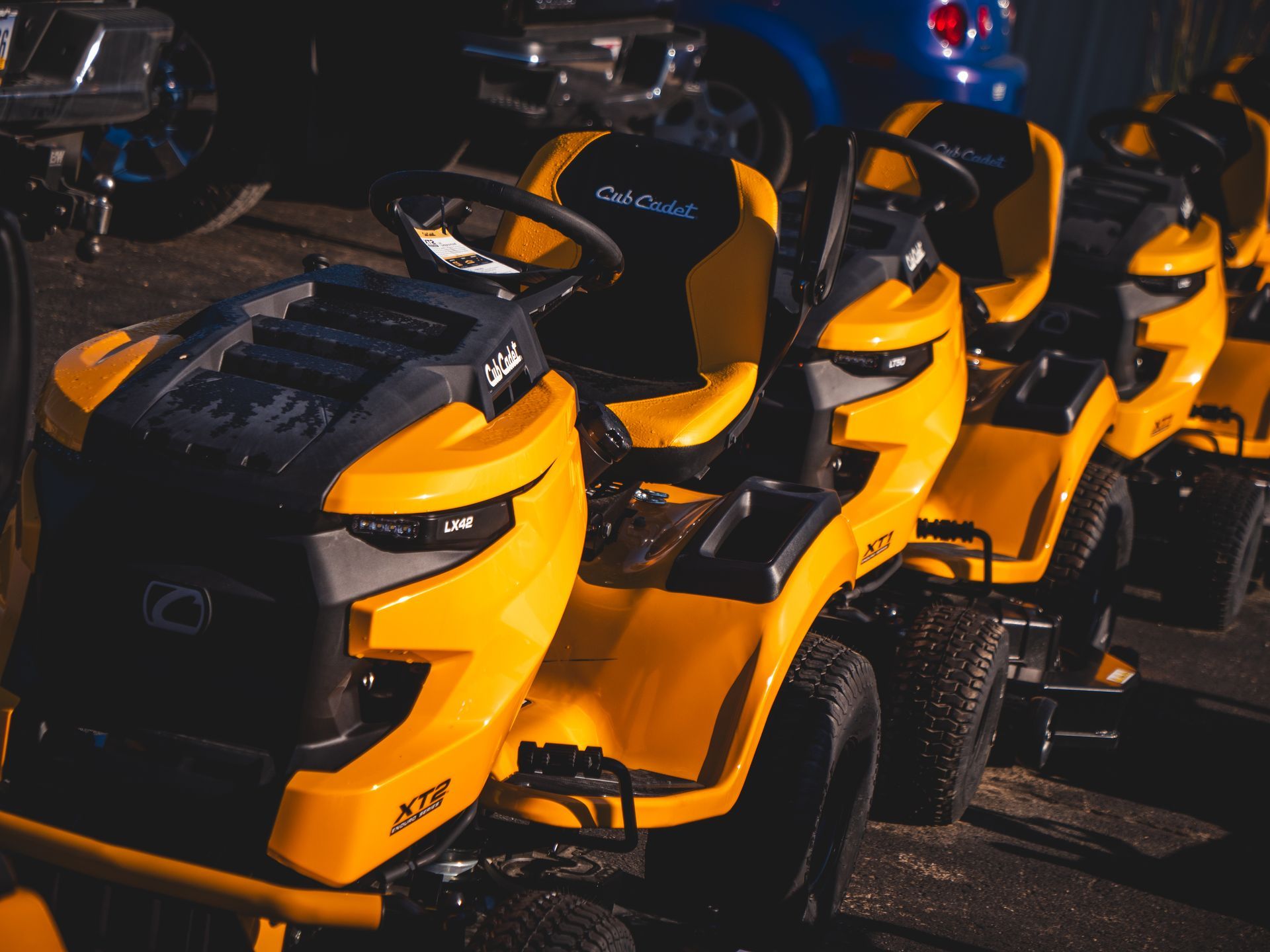 A row of yellow lawn mowers are parked next to each other.