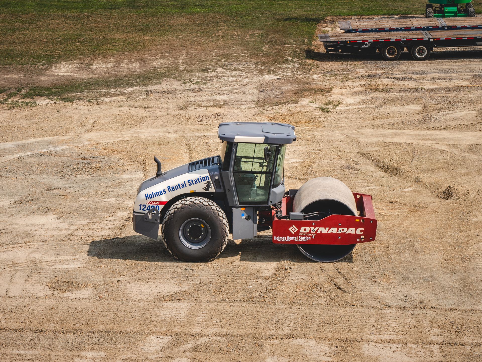 An aerial view of a vibratory roller in a dirt field.