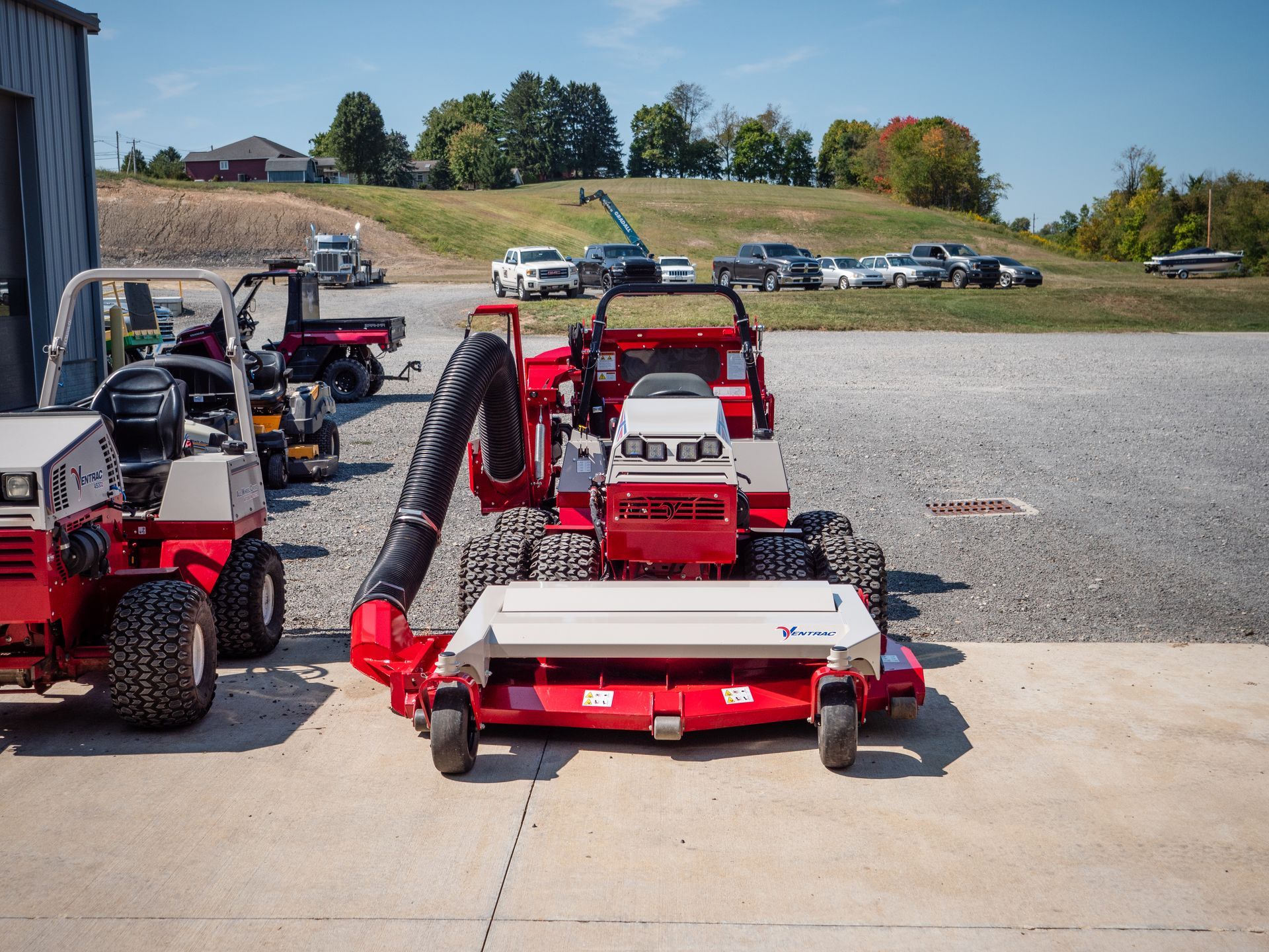 A red lawn mower with a vacuum attached to it
