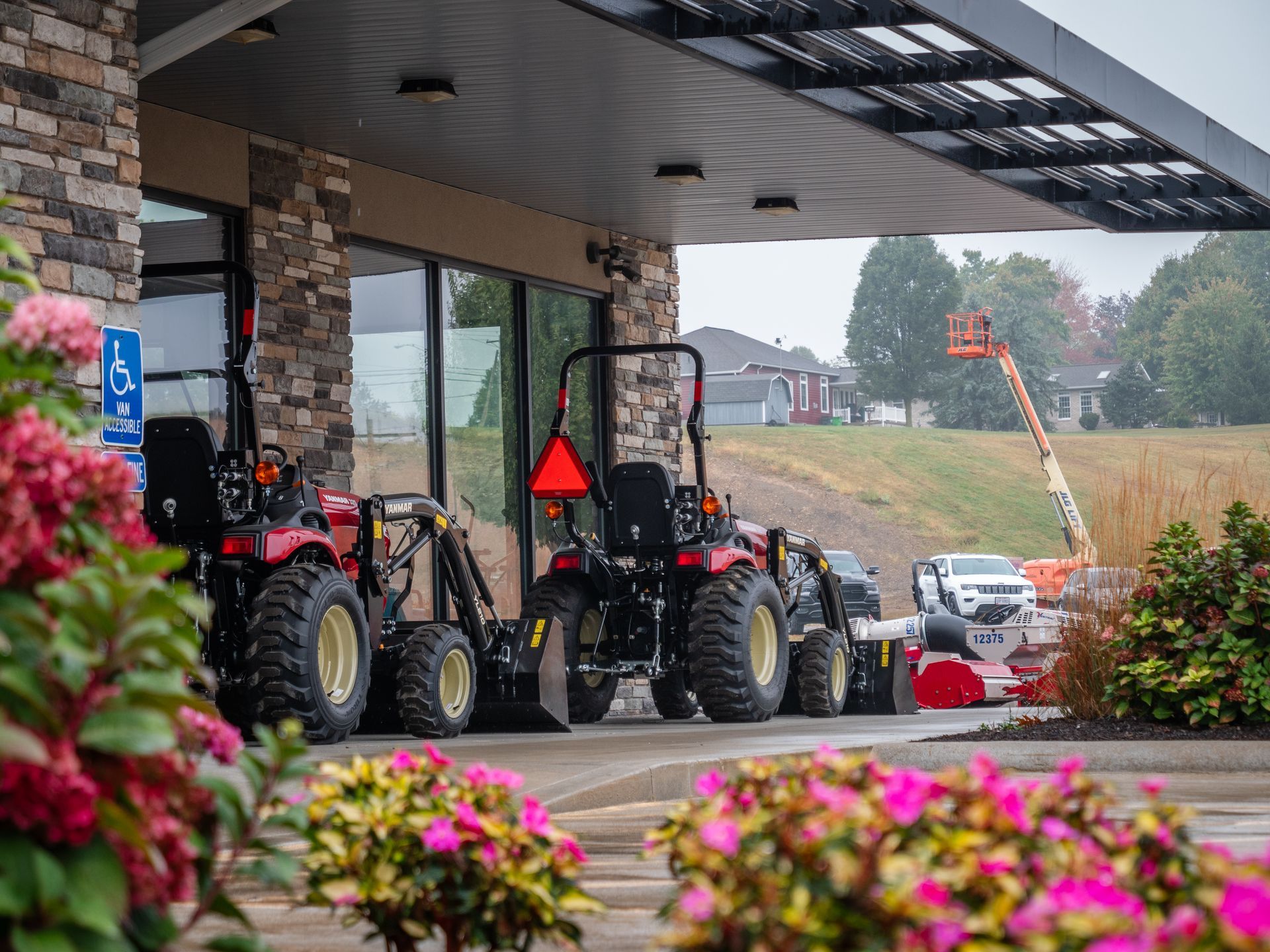 A row of tractors are parked in front of a building.
