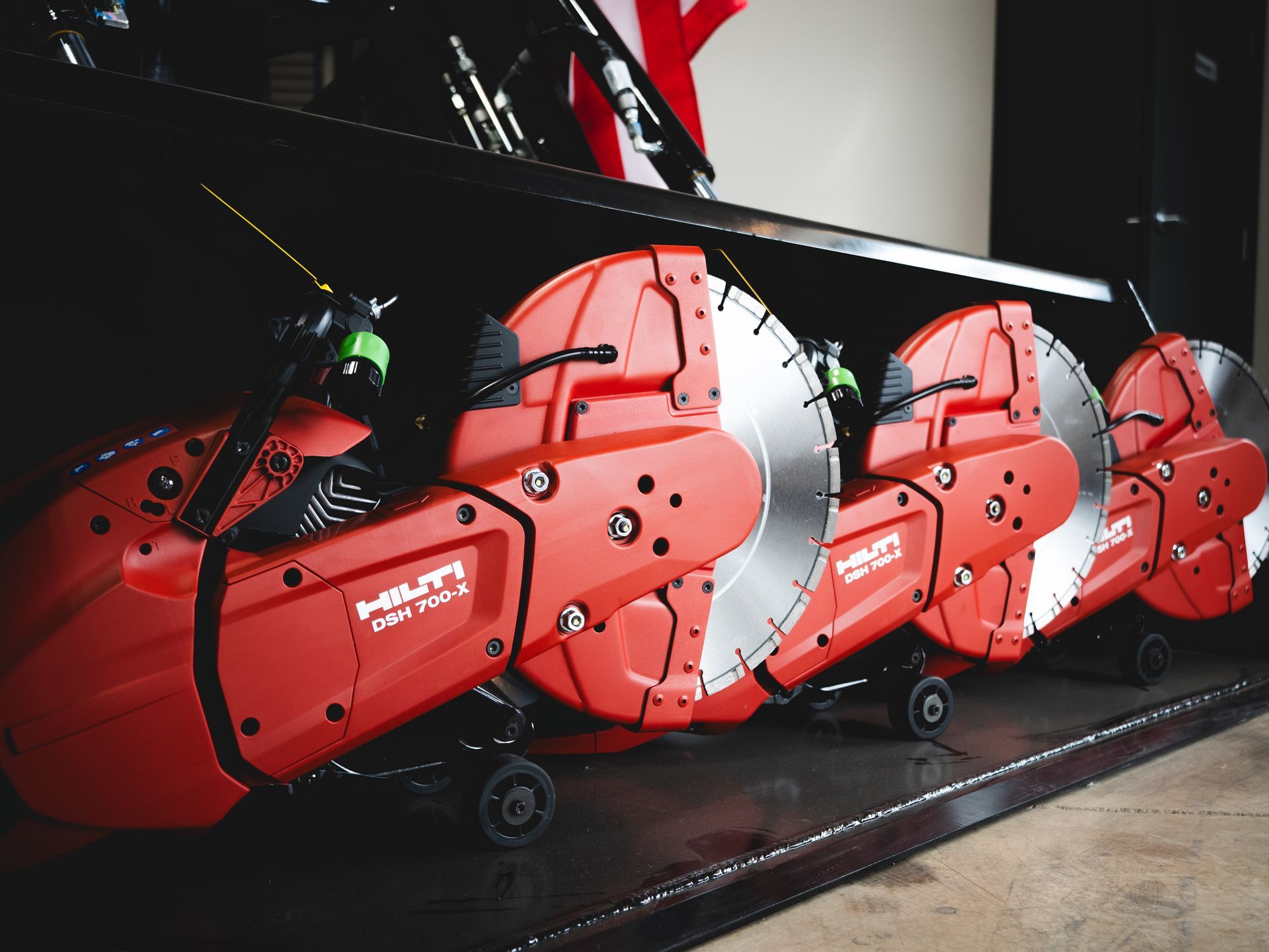 A row of red circular saw blades are lined up on a table.