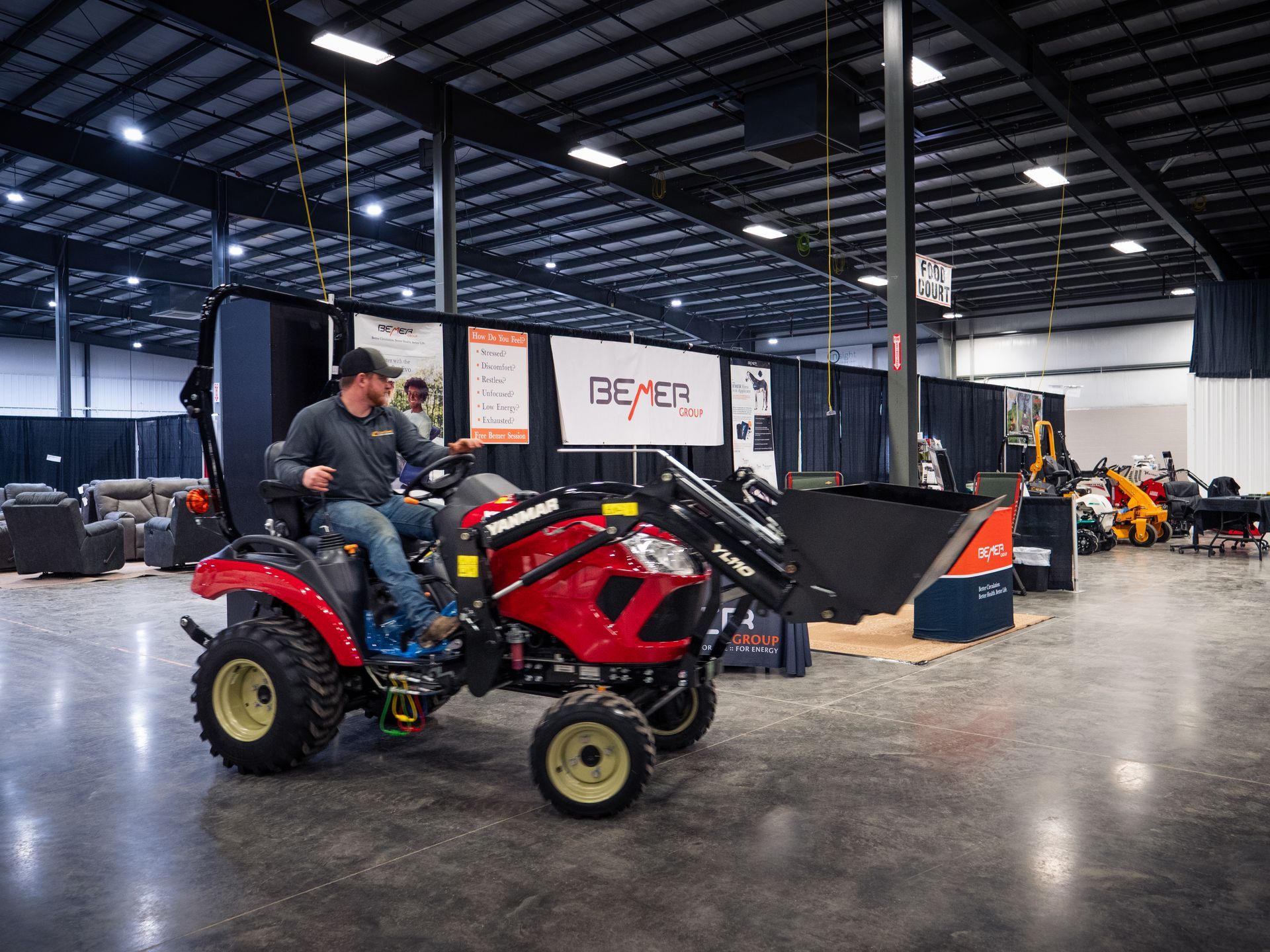 A man is riding a tractor in a large warehouse.