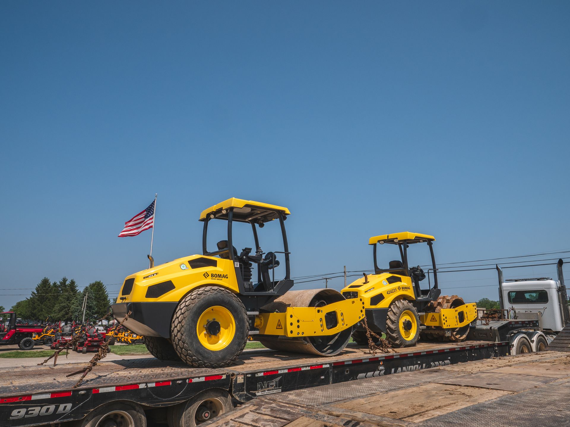 Two yellow tractors are sitting on top of a flatbed truck.
