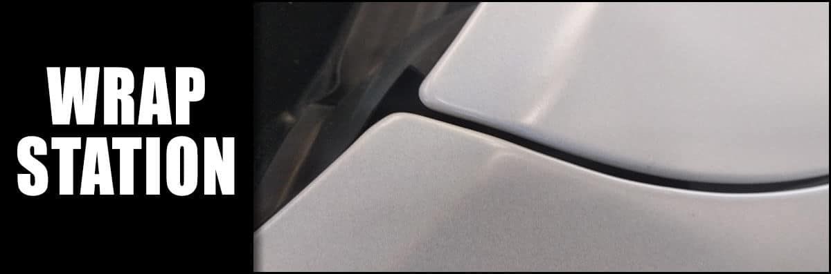 A close up of a white car with the words wrap station above it