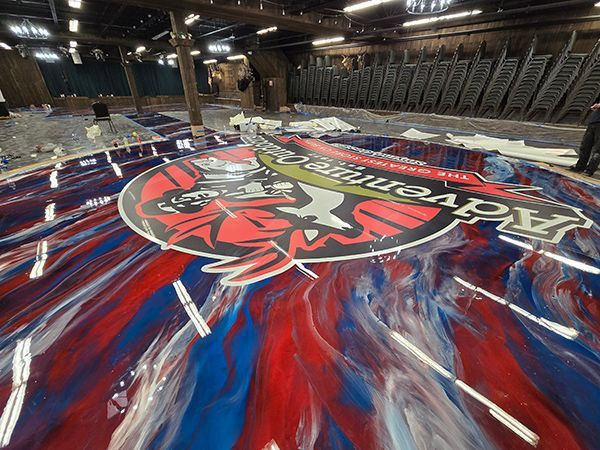 Large logo on wet red, white, and blue floor. 