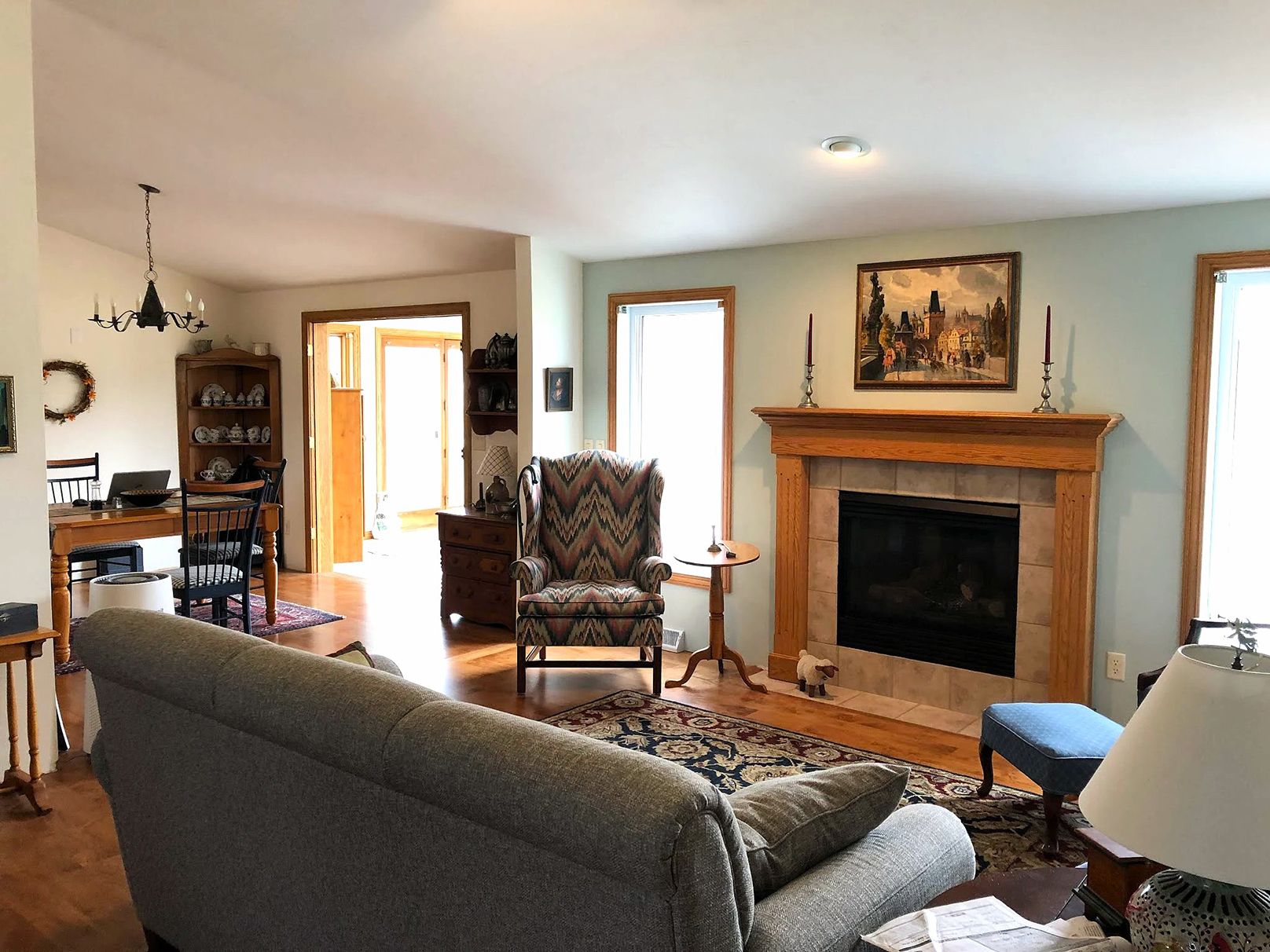 Living room with light walls and a wood fireplace mantel.