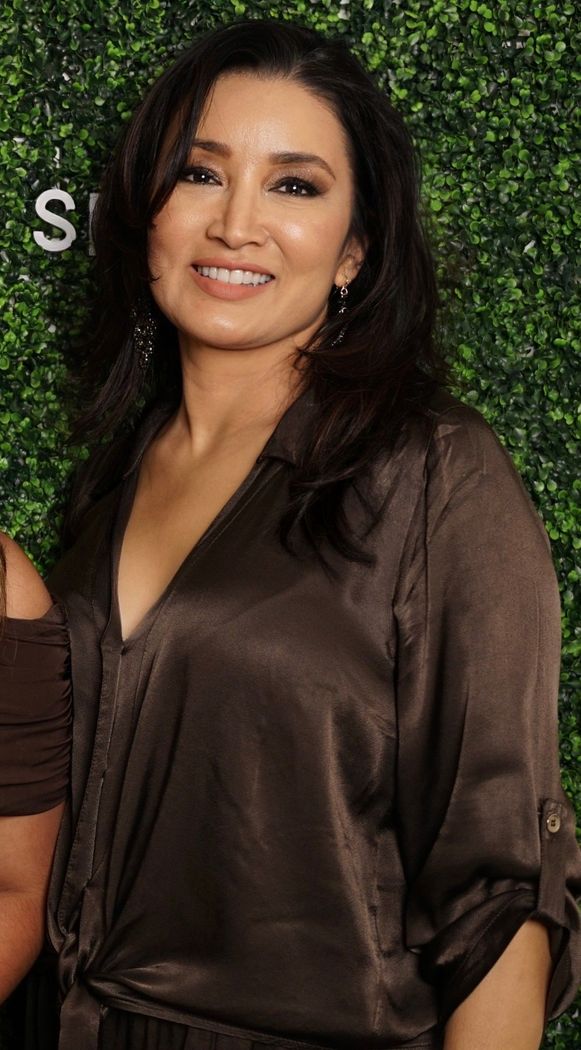 A woman is standing in front of a sign that says a6 skincare