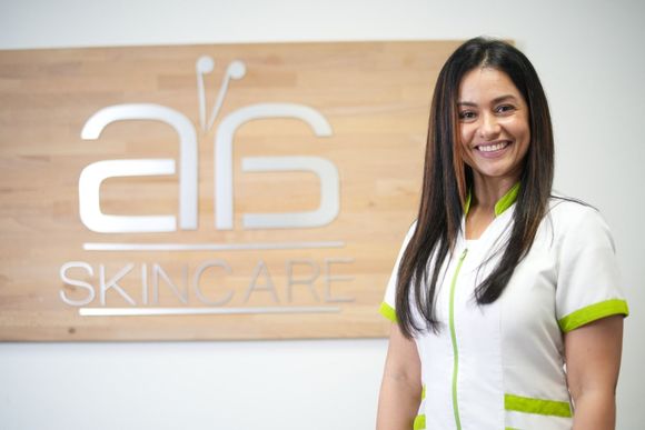 A woman is standing in front of a sign that says skincare