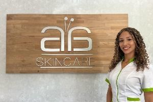A woman is standing in front of a sign that says a6 skincare.