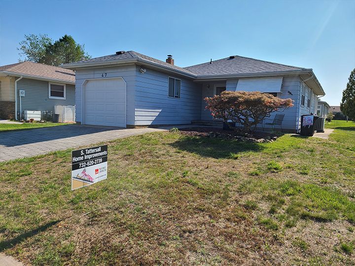 A house with a for sale sign in front of it.