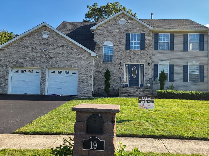 A large brick house with a mailbox in front of it