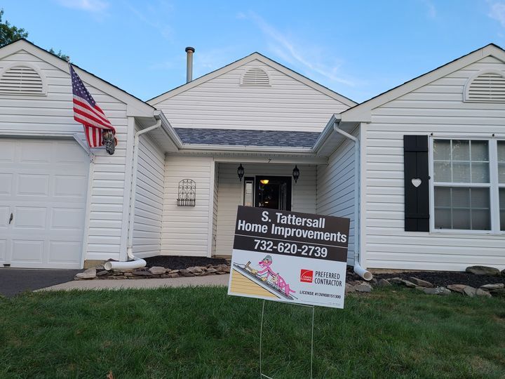 A white house with a sign in front of it that says home improvements