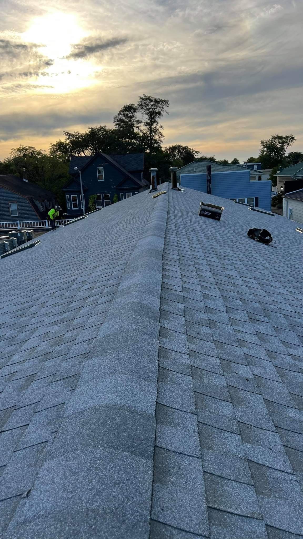 A roof with a lot of snow on it and a sunset in the background.