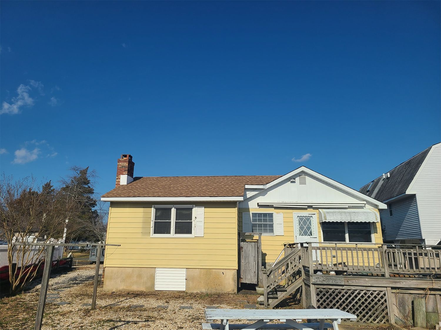 A yellow house with a chimney on top of it