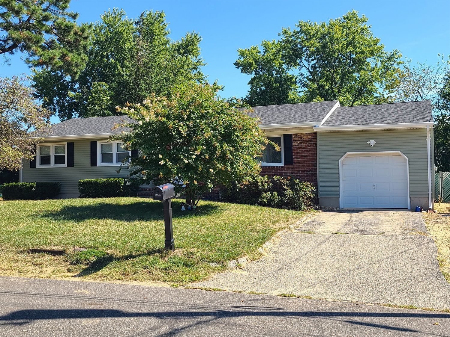 A house with a garage and a mailbox in front of it