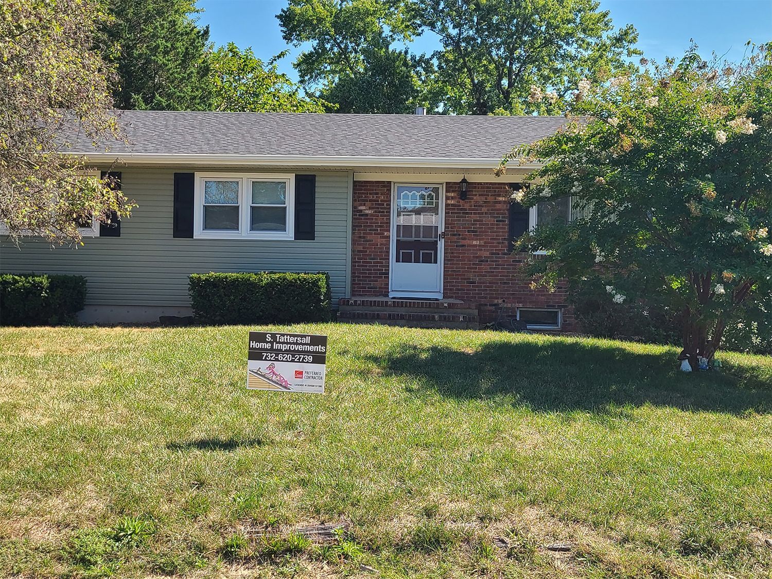 A house with a for sale sign in front of it