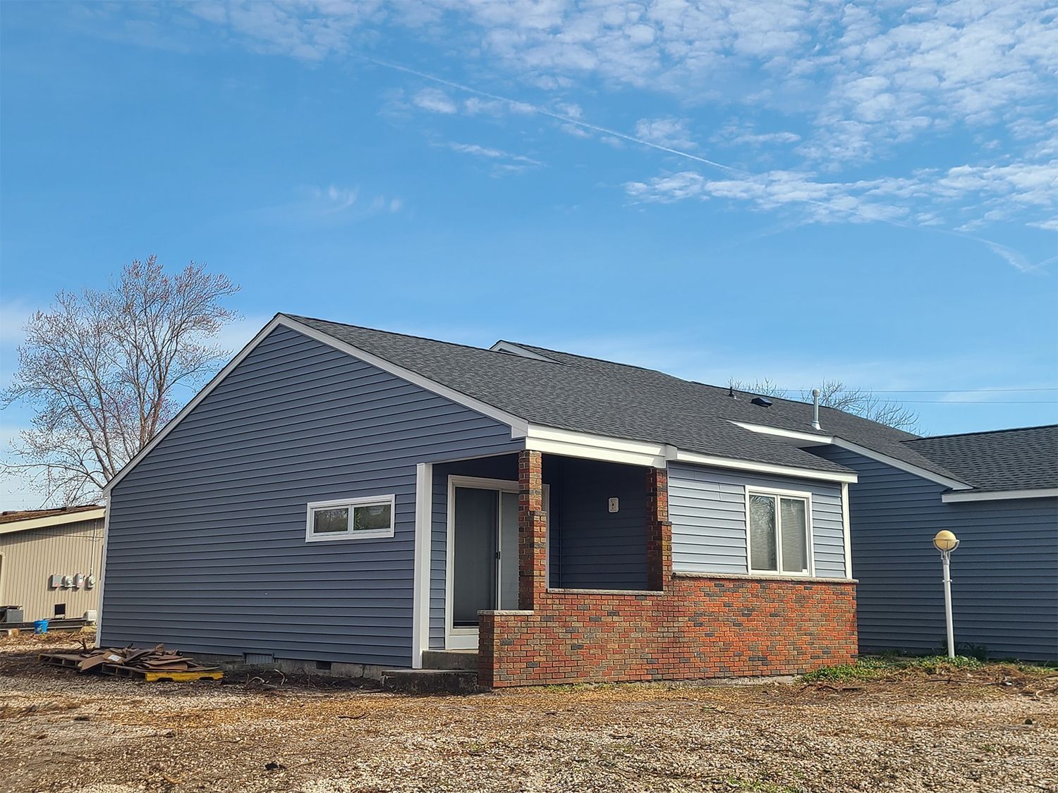 A small house with a porch and a train in the background.