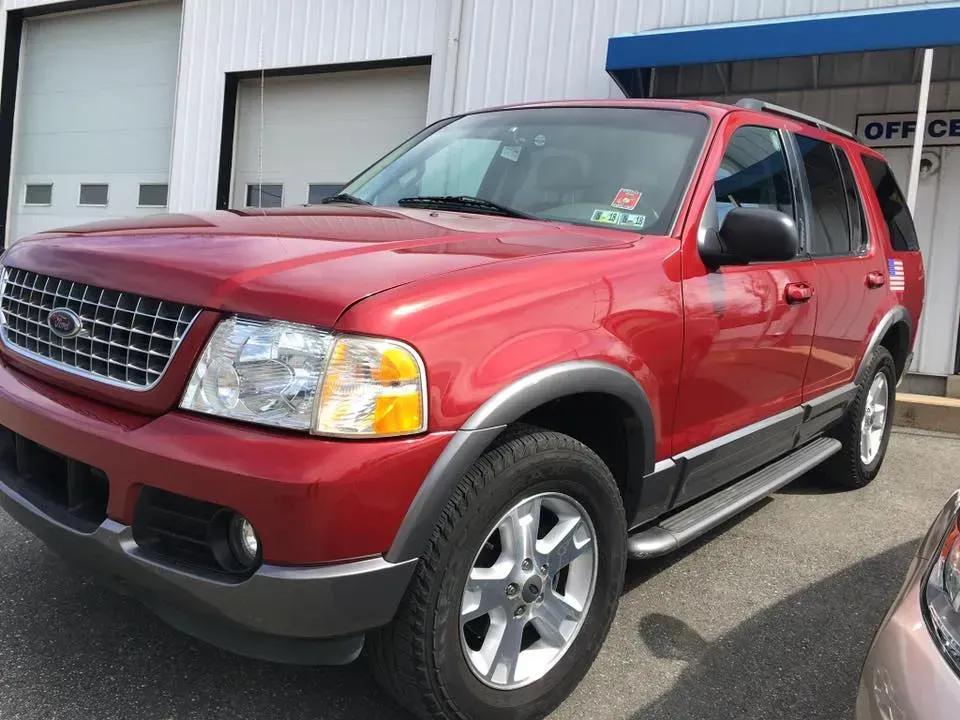 Red SUV parked outside a building, front three-quarter view.