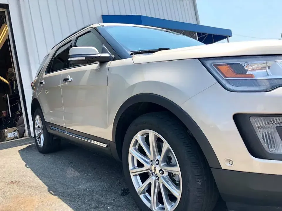 Silver SUV parked outside a garage, front three-quarter view