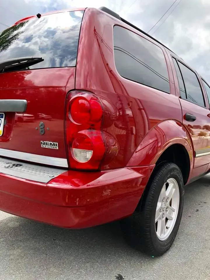 Red SUV parked on a street, rear three-quarter view, with tinted windows and silver wheels