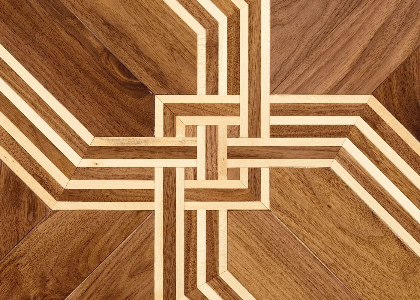 Wooden floor with a repeating geometric pattern of light and dark wood in a cross shape.