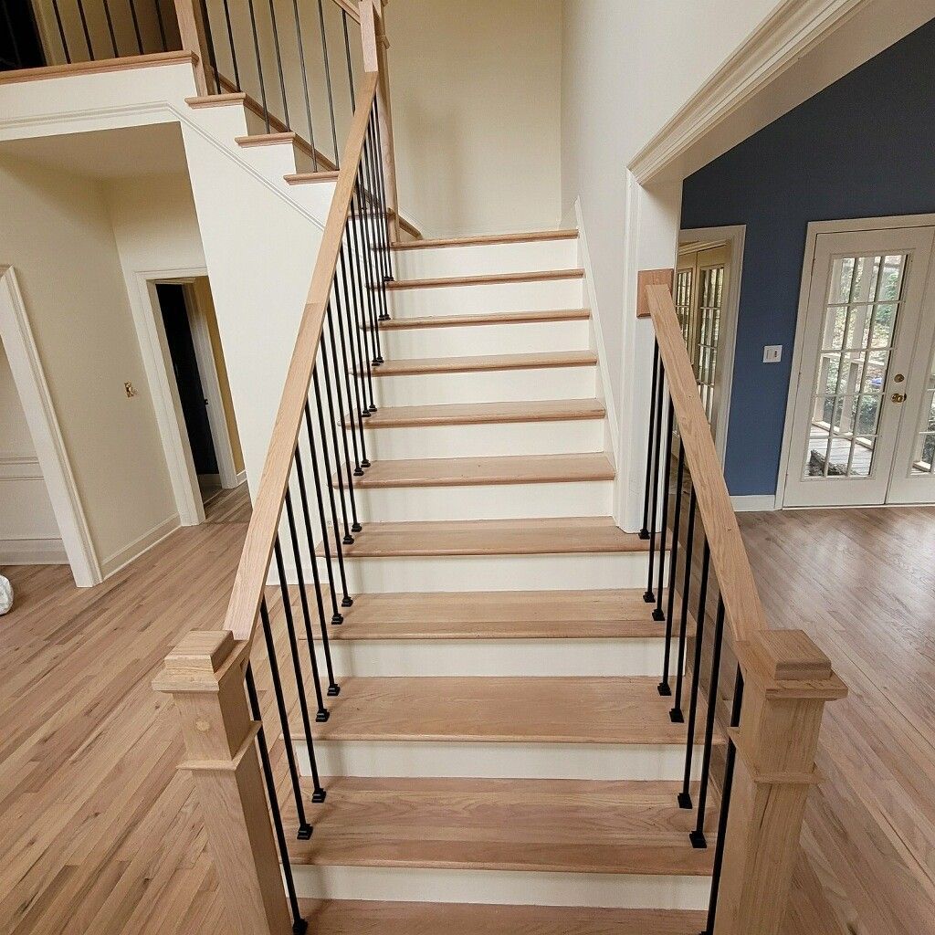 Wooden staircase with black metal balusters, leading up
