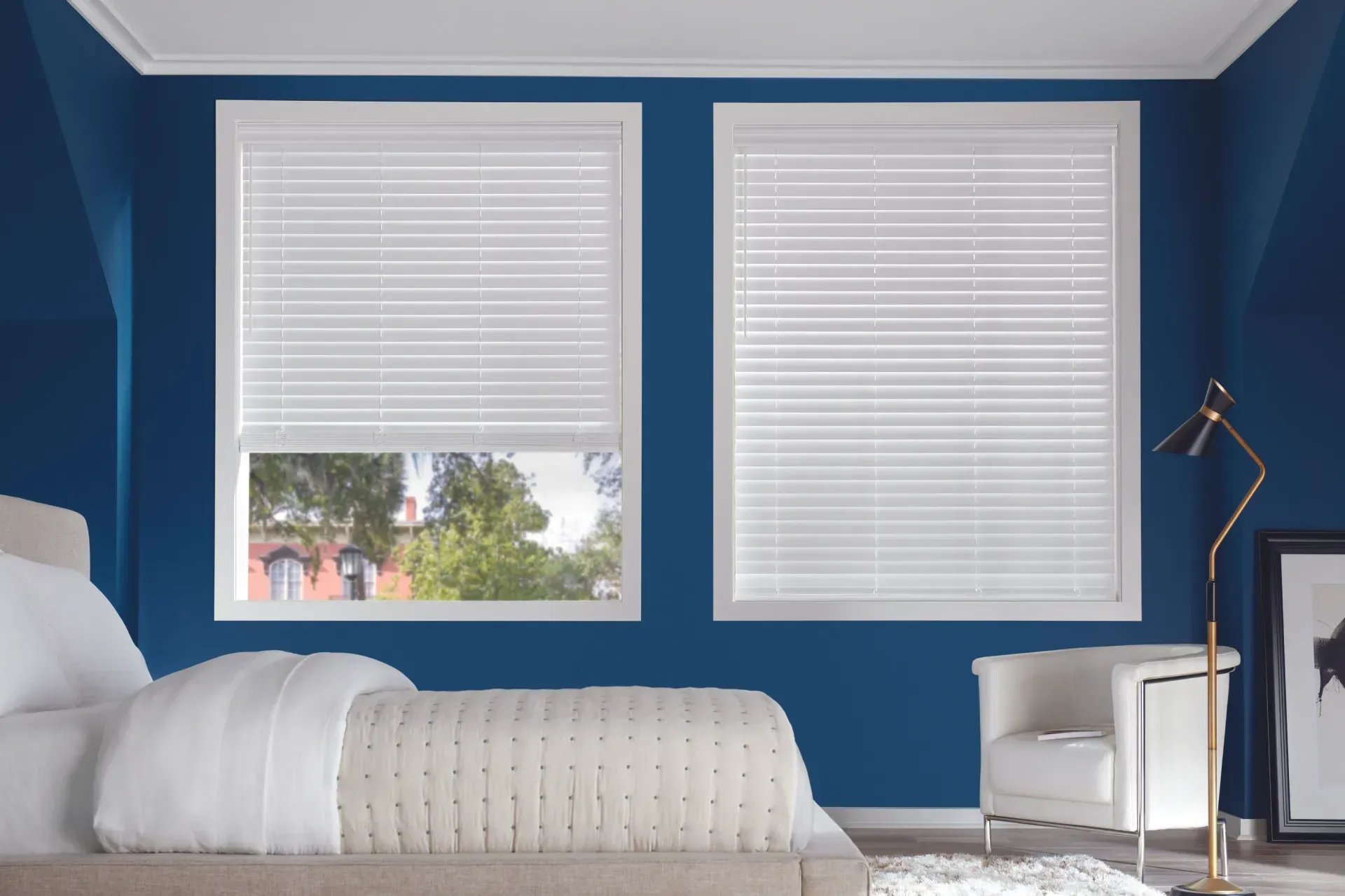 A bedroom with blue walls and white blinds on the windows.