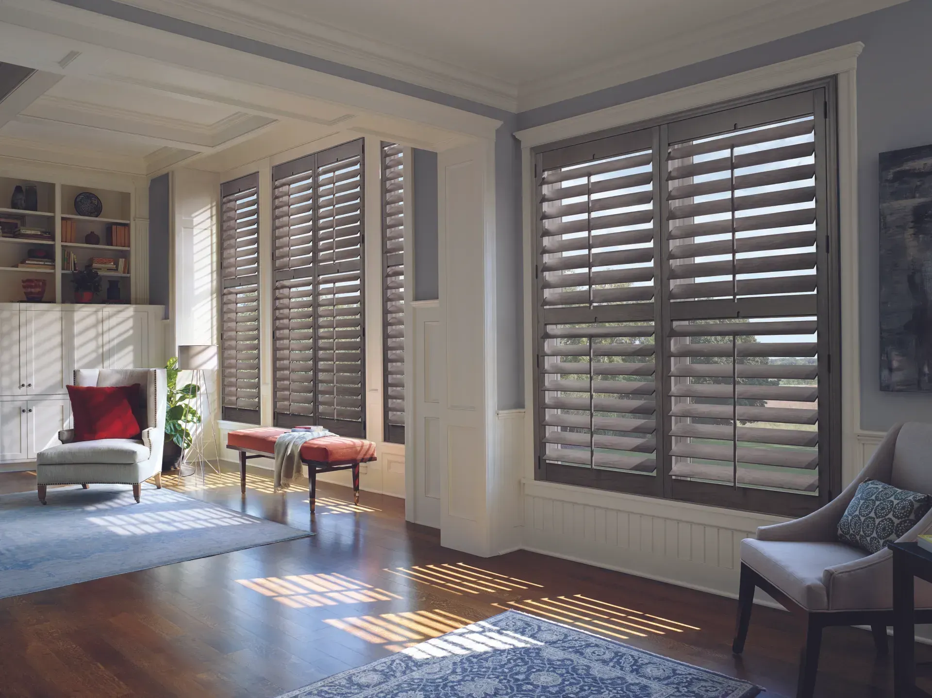 A living room with hardwood floors and shutters on the windows