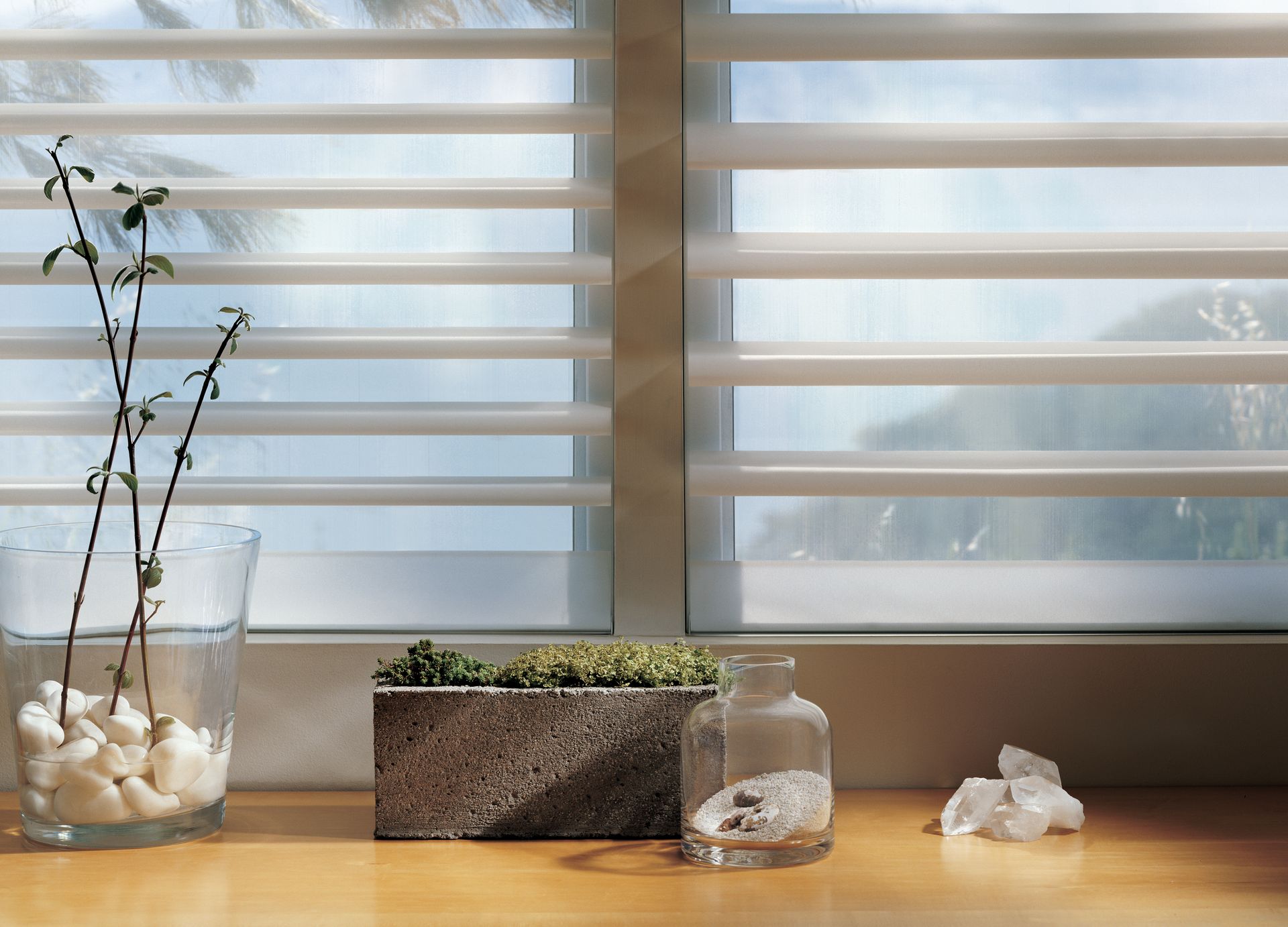 A window with white blinds and a plant in a vase