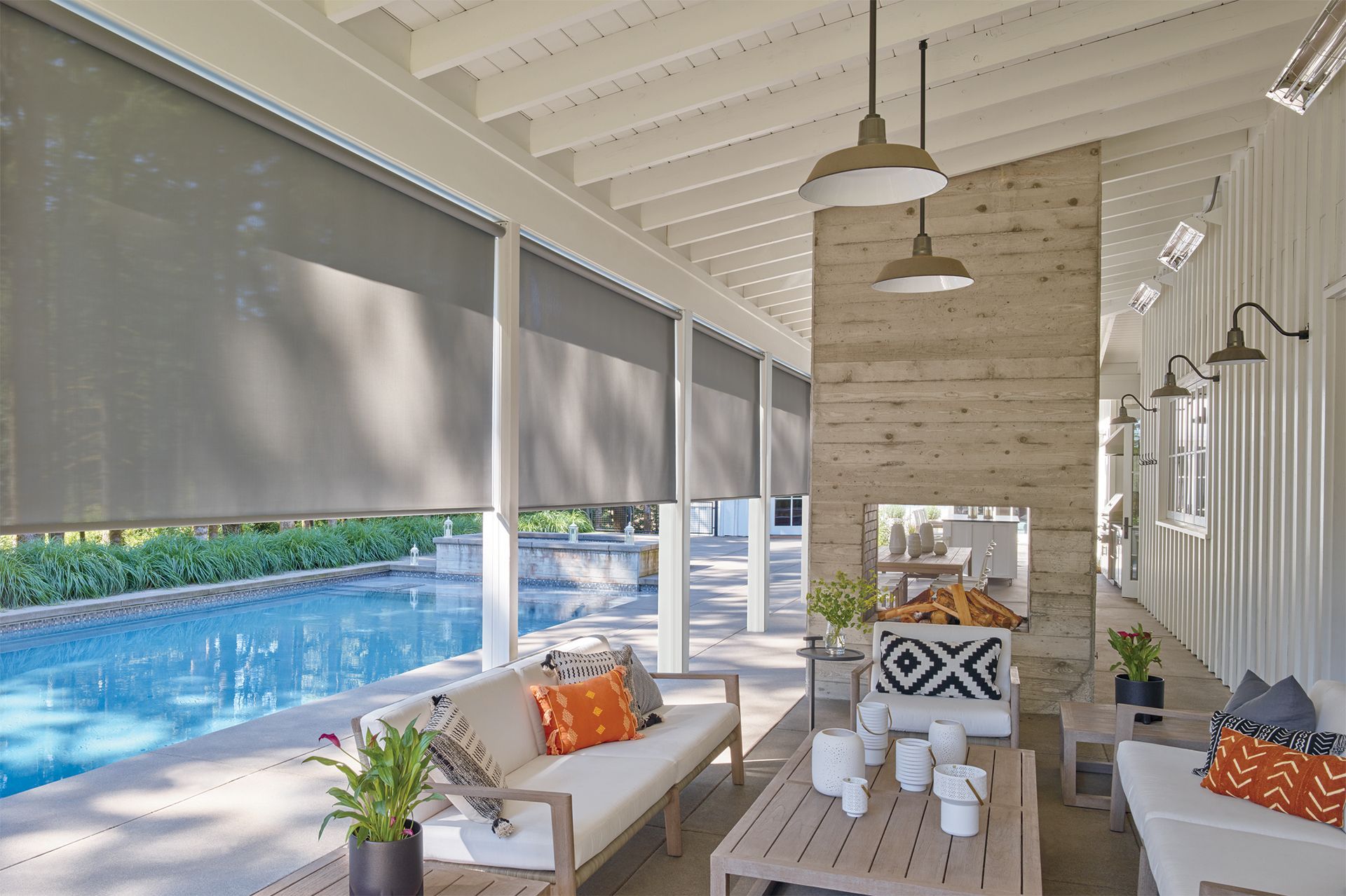 A living room with a couch , table , chairs and a swimming pool.