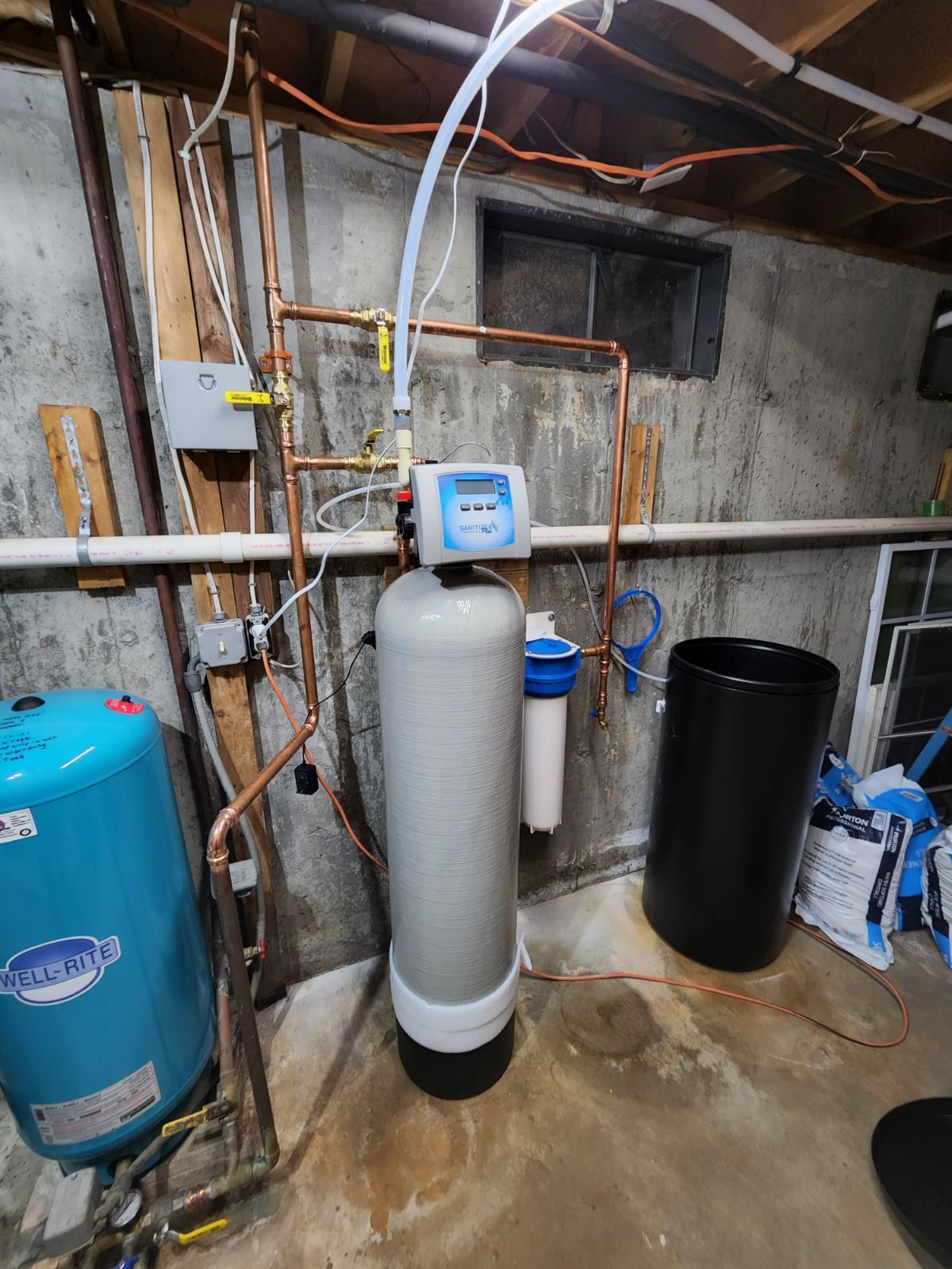 a blue Well-Rite tank, a gray tank, and a black container