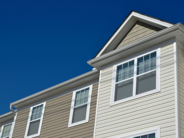 White house siding and windows under a bright blue sky