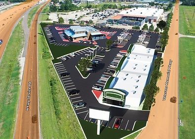Aerial view of a business complex with parking lots beside a highway and green fields
