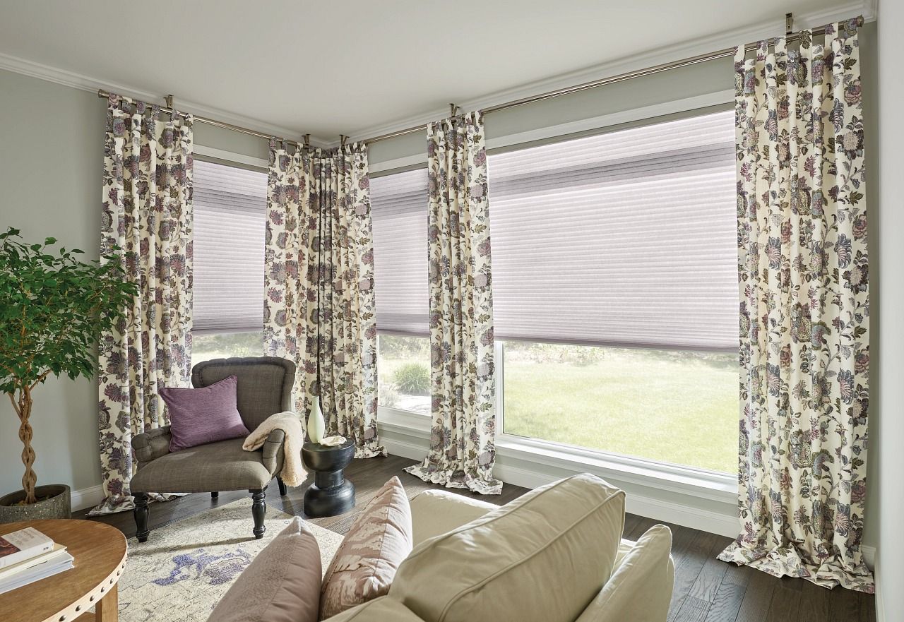 A living room with a couch , chair , and curtains.