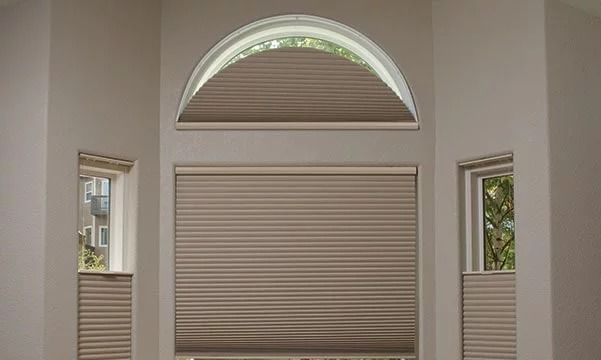 A room with a window with a honeycomb blind on it.