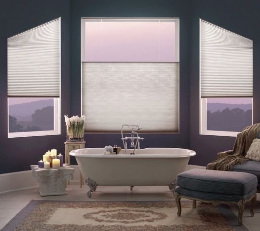 A bathroom with a tub and two windows with blinds