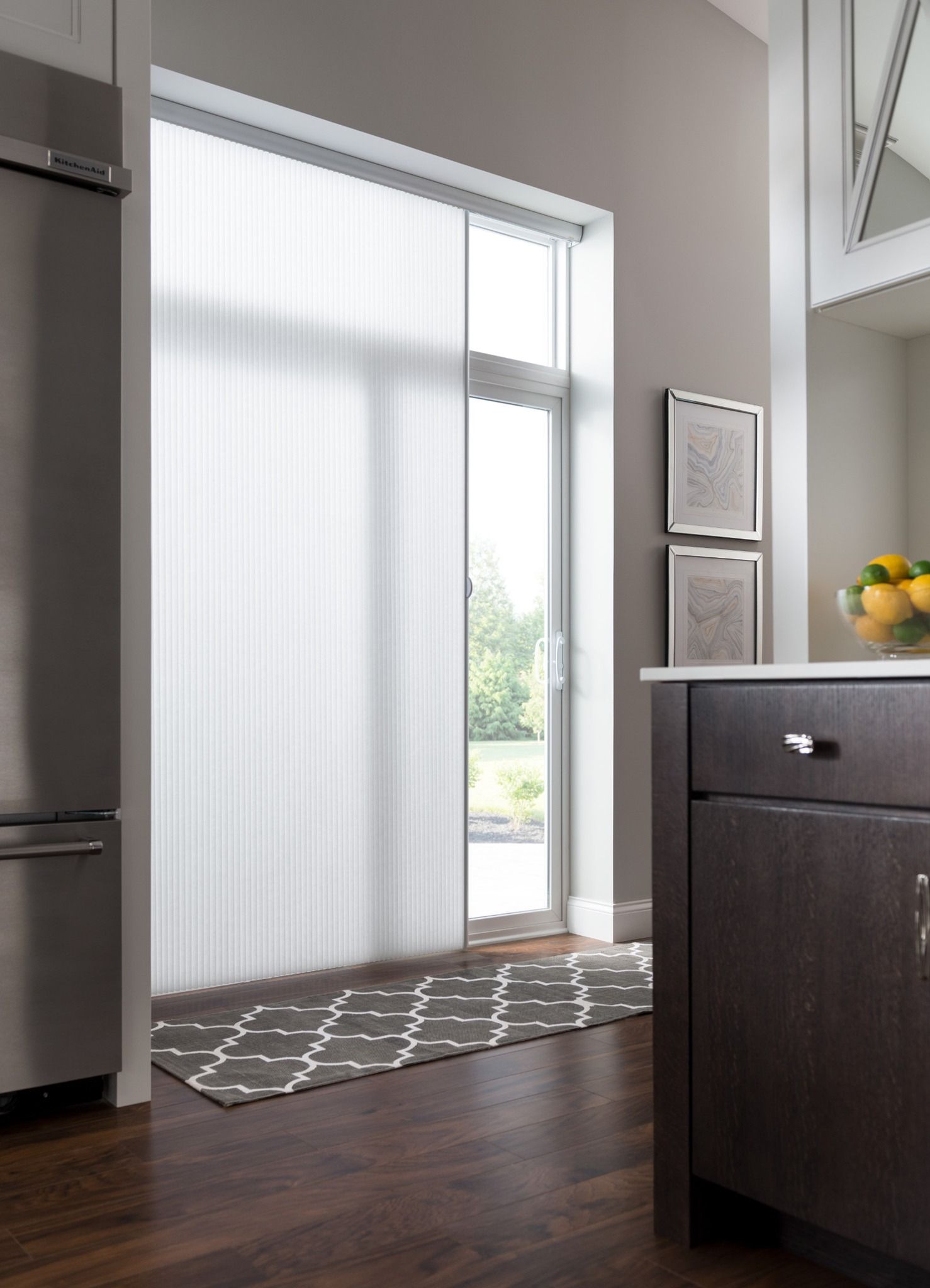 A kitchen with a sliding glass door and a stainless steel refrigerator