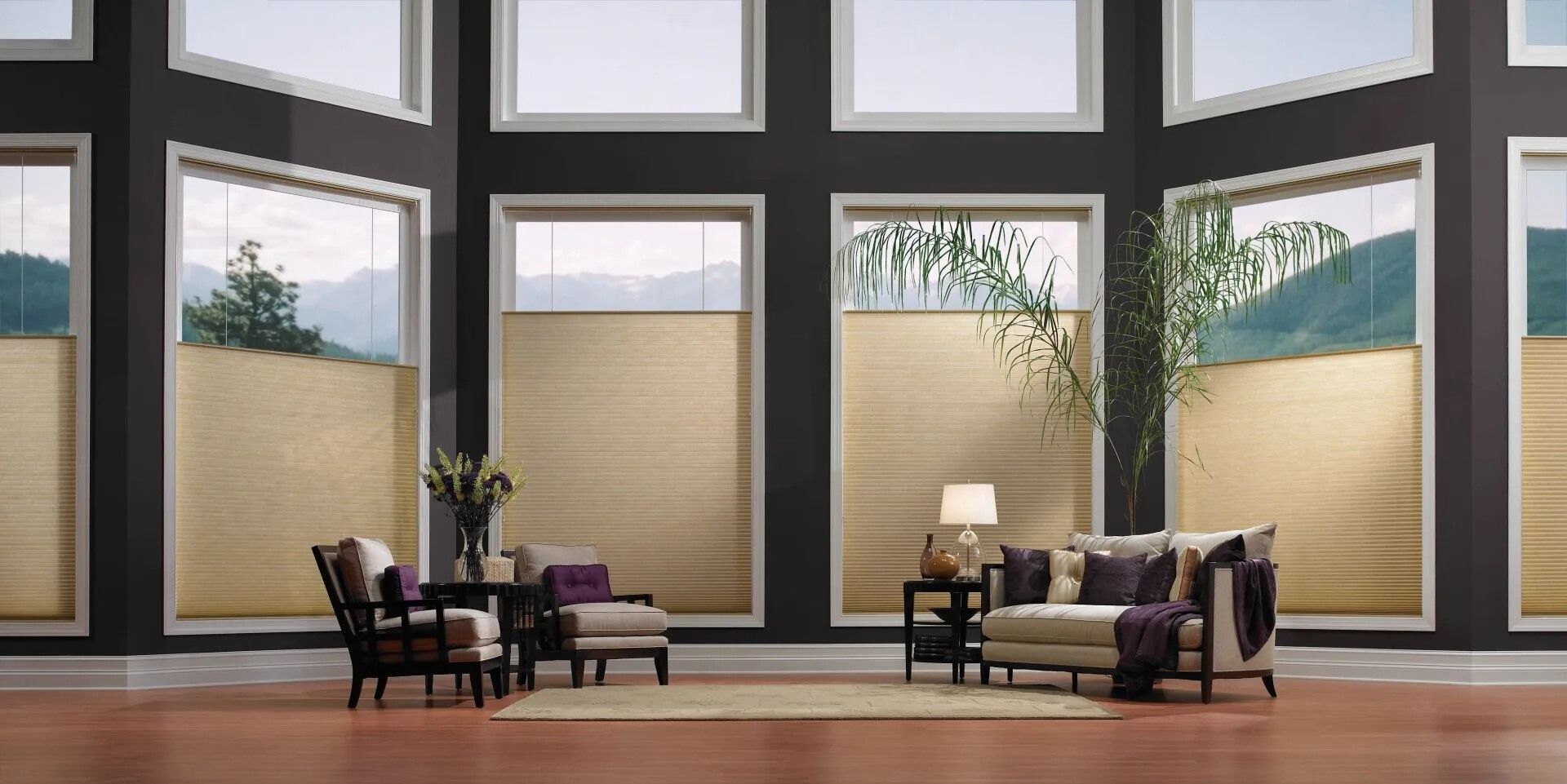 A living room with a lot of windows and a couch and chairs