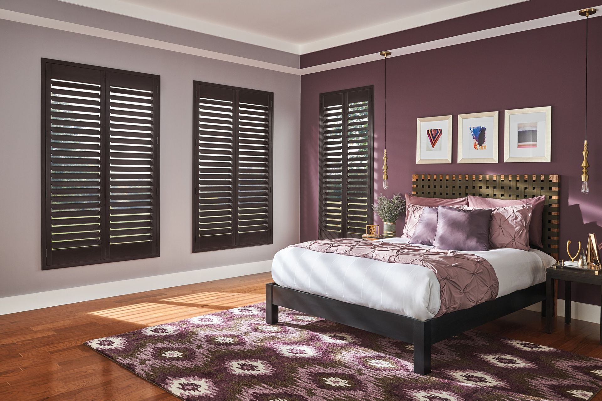 A bedroom with purple walls , a bed , a rug and shutters.