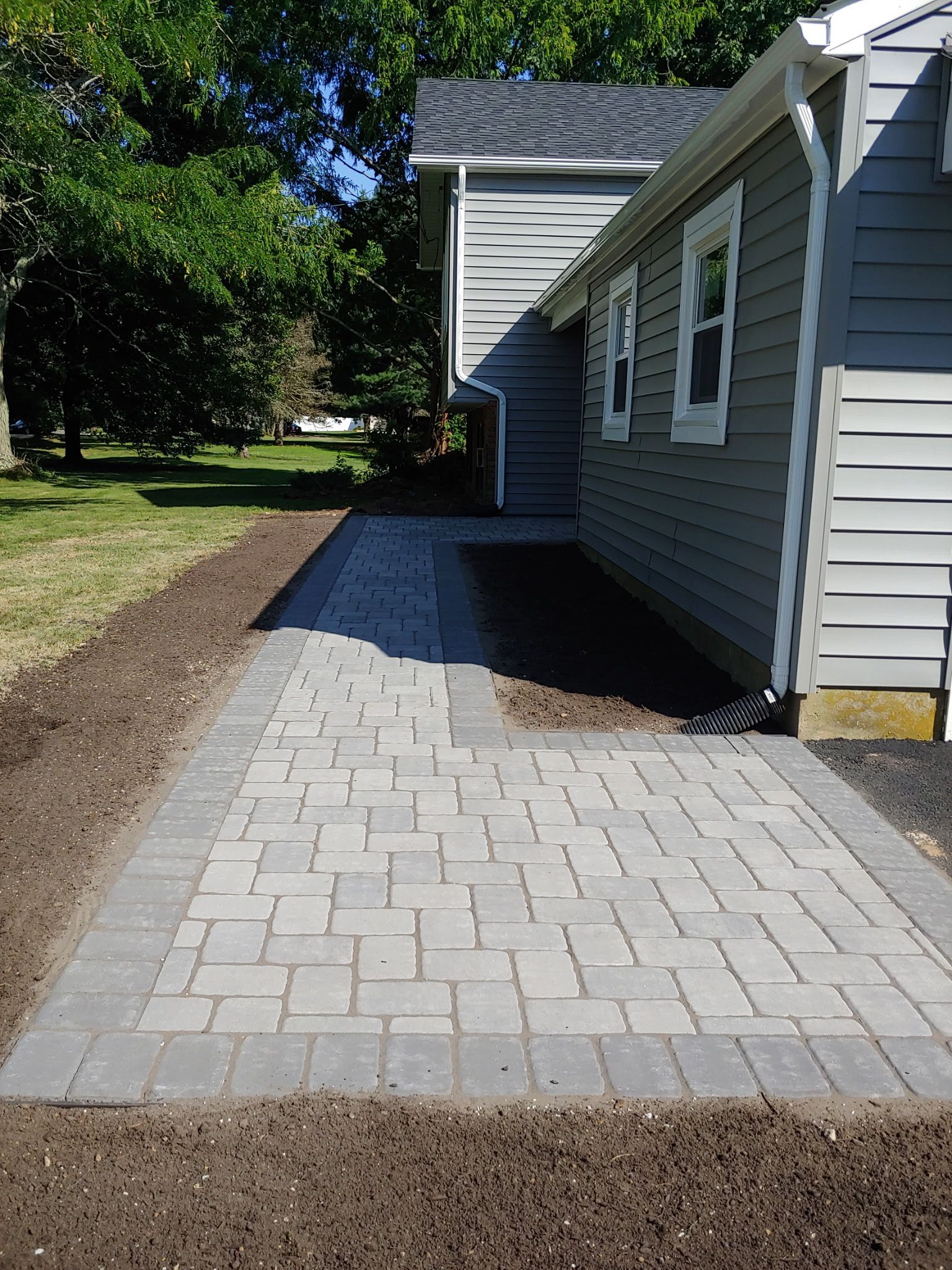 A brick walkway leading to the side of a house.