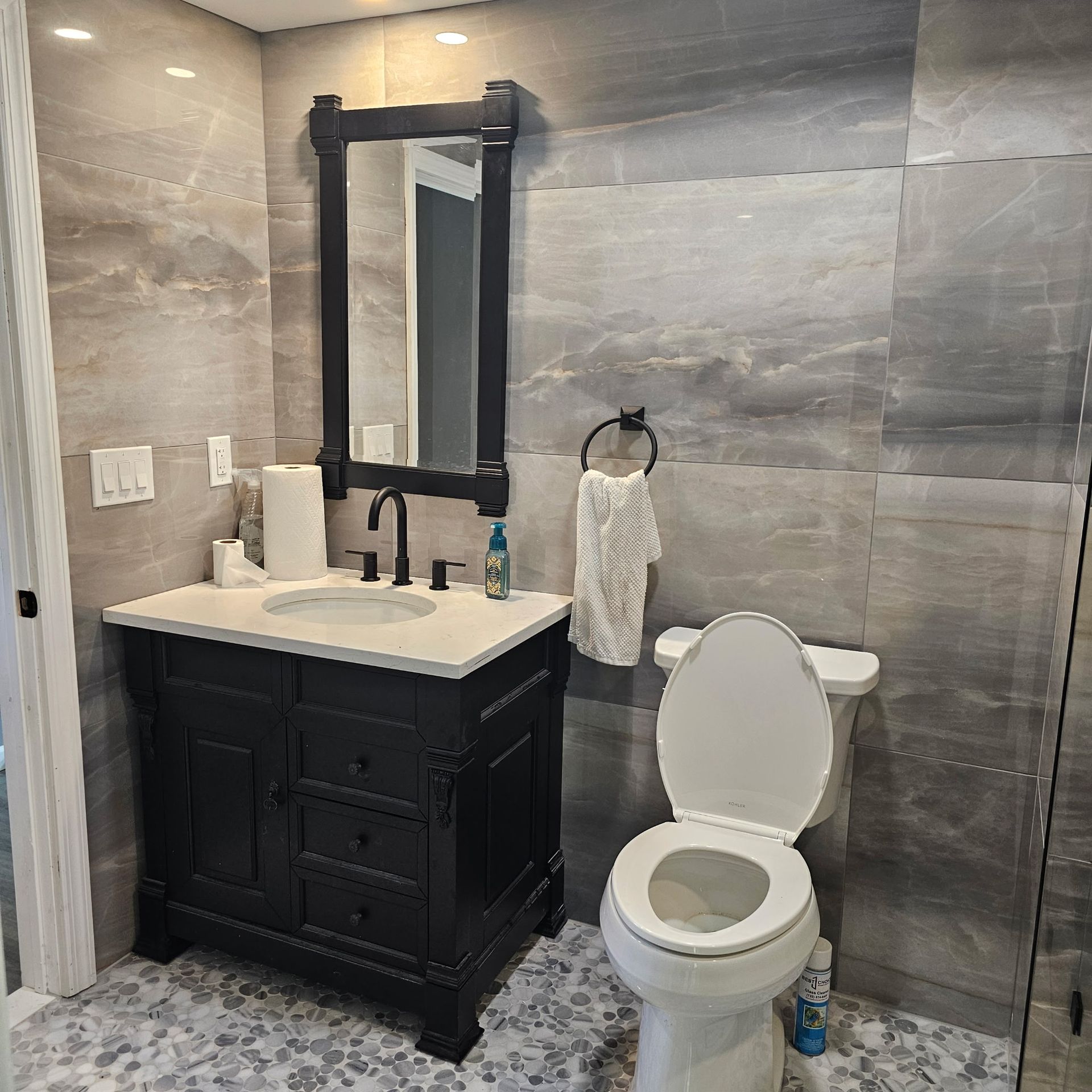 A bathroom with a sink , toilet and mirror.