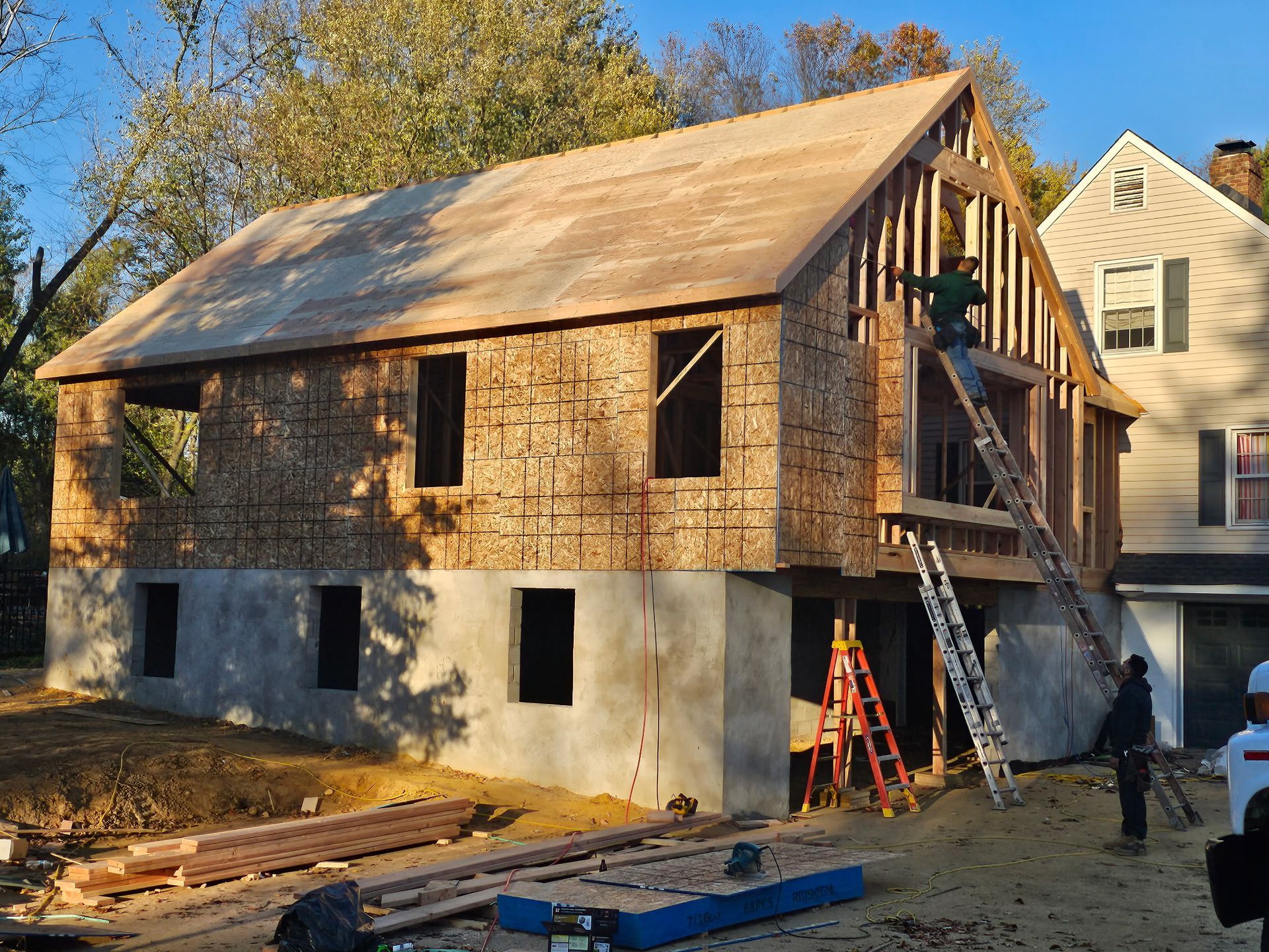 A house is being built with plywood and a ladder.