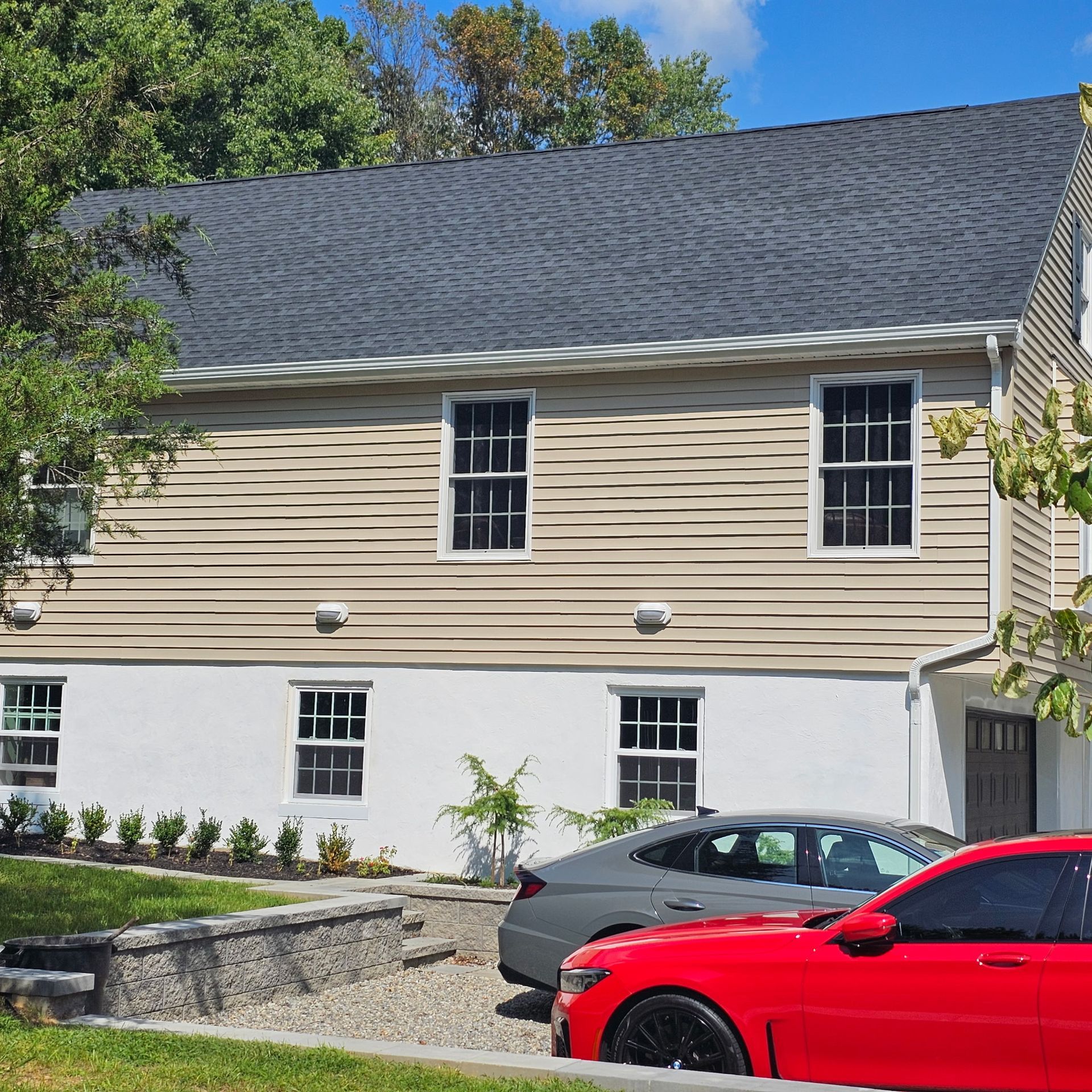 A red car is parked in front of a house
