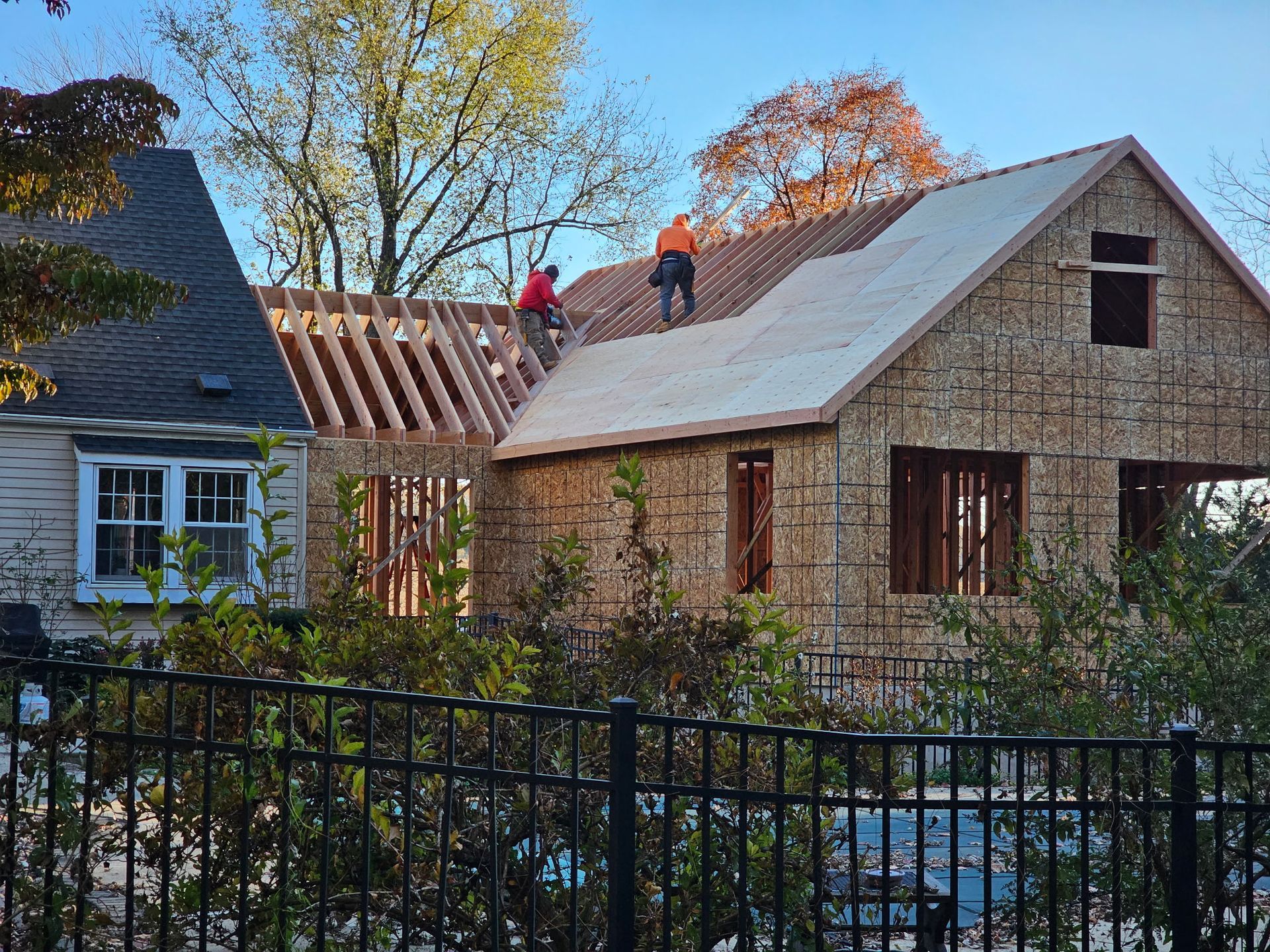 Two men are working on the roof of a house