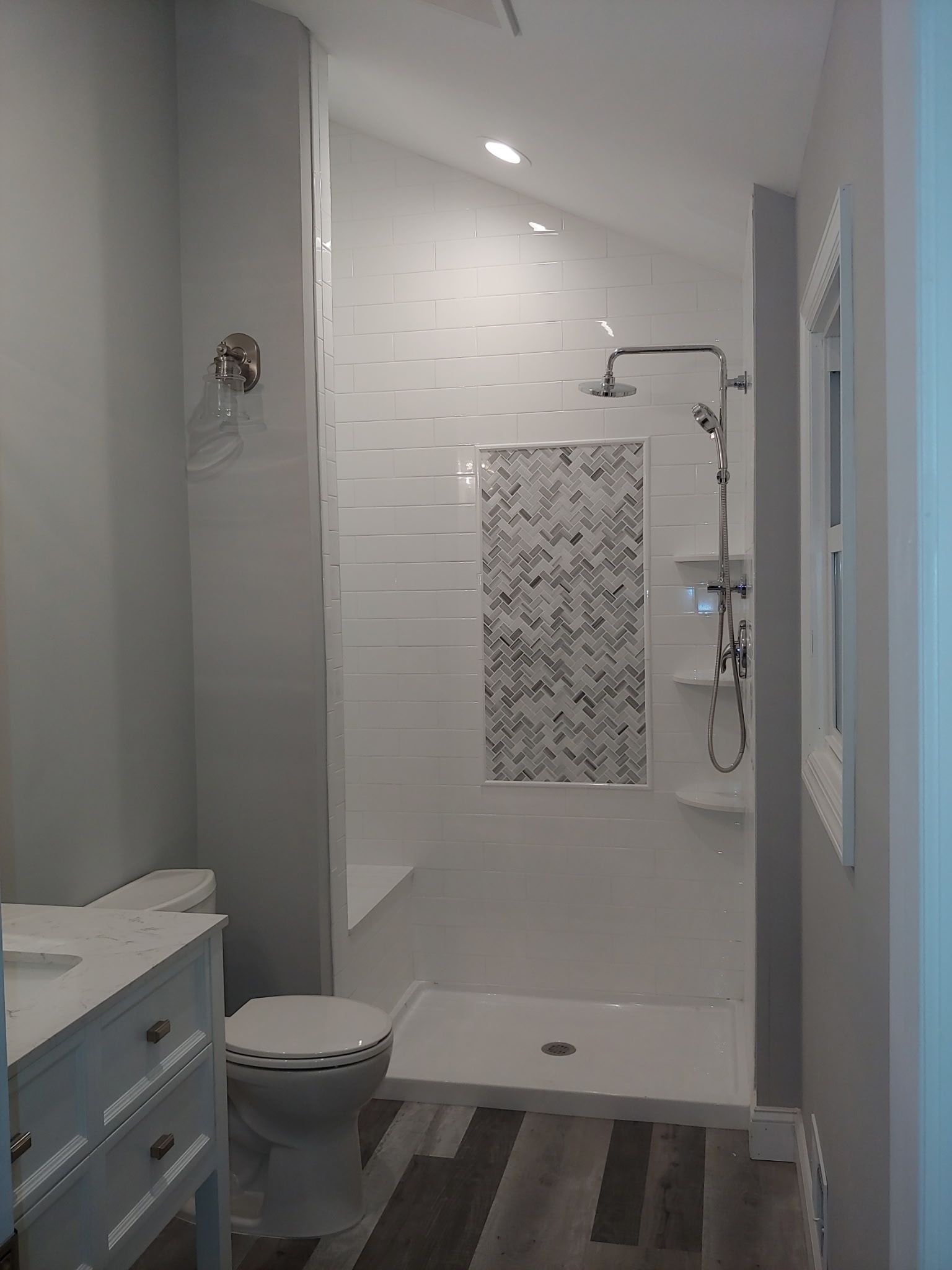 A bathroom with a toilet , sink and shower.