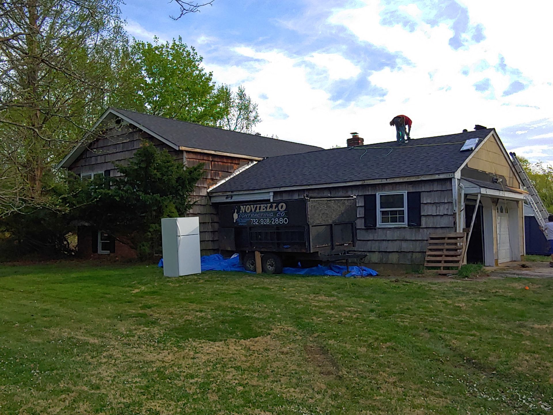 A man is working on the roof of a house.